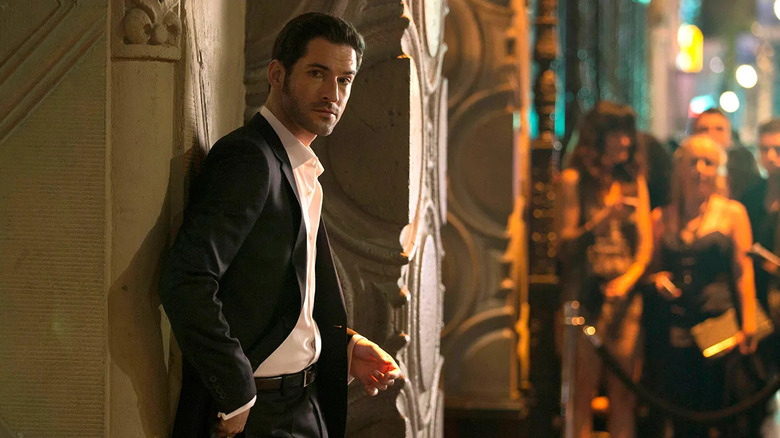 Lucifer reclines against the wall wearing a suit inside a nightclub in "Lucifer"