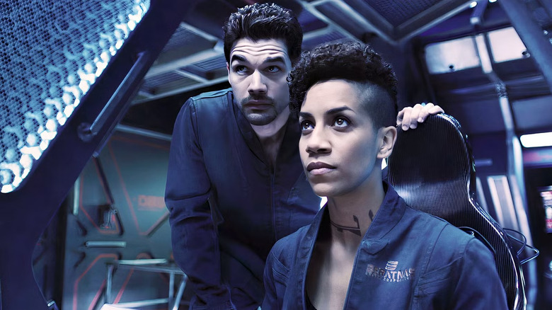 James Holden looks over the shoulder of Naomi Nagata inside a spaceship in "The Expanse"