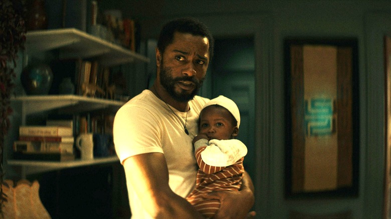 Apollo cradles his baby and looks worried.