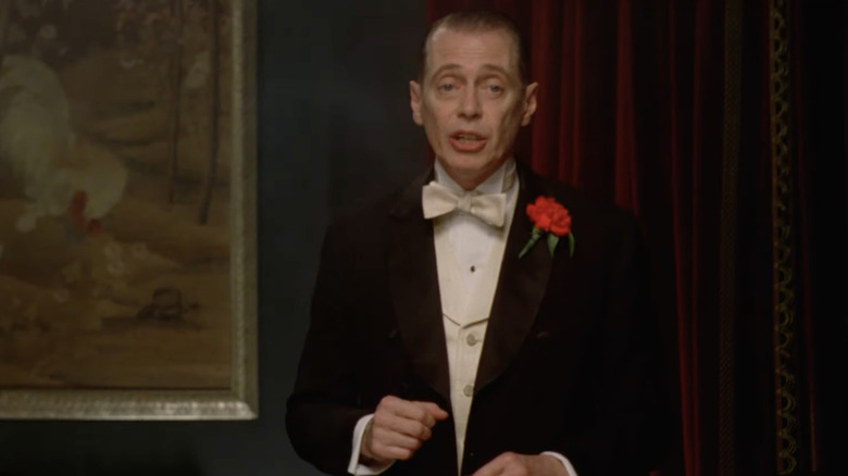 Nucky Thompson in tuxedo speaking at dinner party