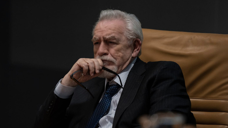 Logan Roy in tan leather chair scowling