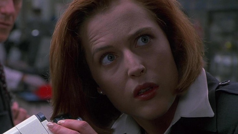 Scully looks up from a microsope
