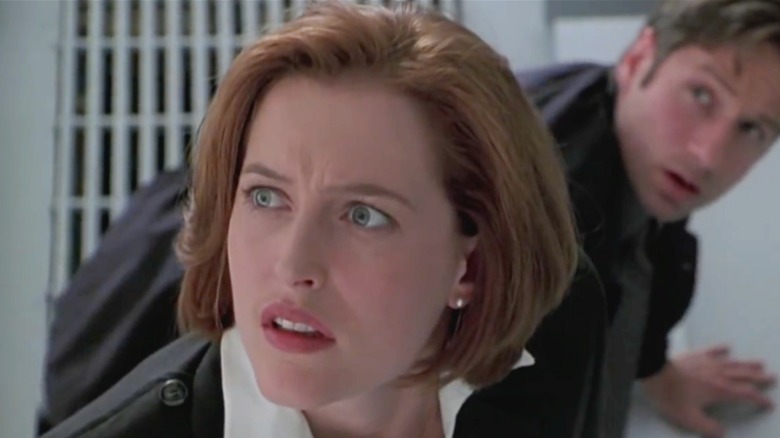Scully looks up from a microsope