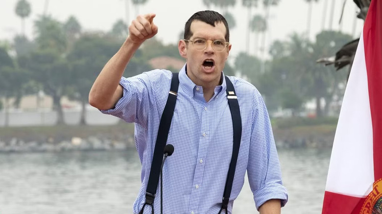Jonah Ryan standing in front of a body of water, shouting and pointing from a podium in Veep