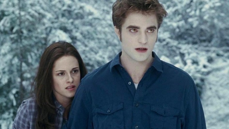 Bella and Edward standing in snowy forest looking worried