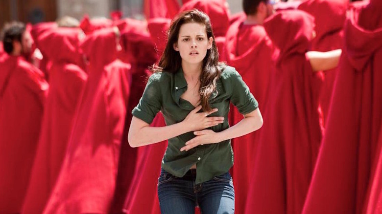 Bella running through a crowd in red cloaks in The Twilight Saga: New Moon