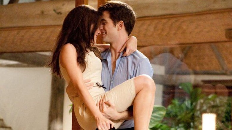 Edward sits in bed with Bella