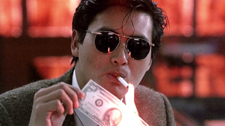 Tse-Ho burns a bank note