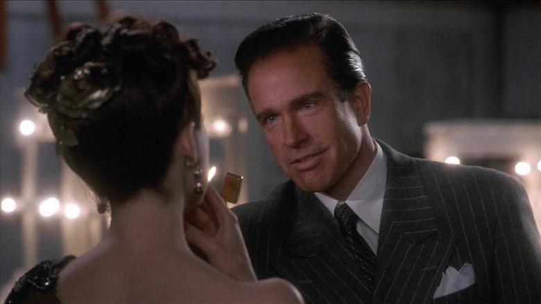 Bugsy lights a woman's cigarette