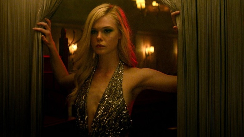 Elle Fanning walking through a curtain