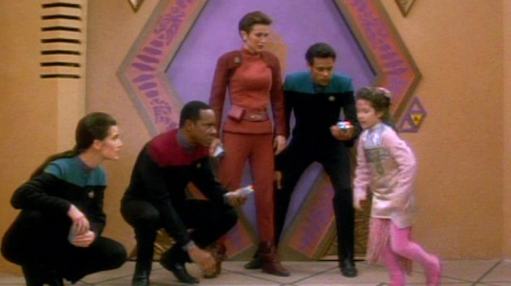 Dax, Sisko, Kira, and Bashir play hopscotch with a board game character