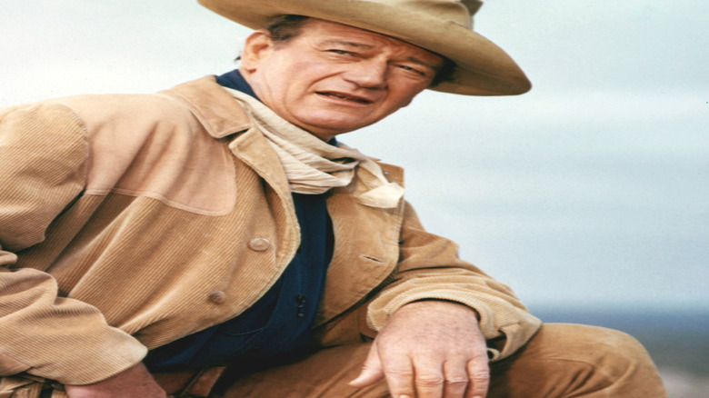 John Wayne leans forward and squints