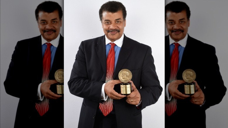 Neil deGrasse Tyson smiling with an award