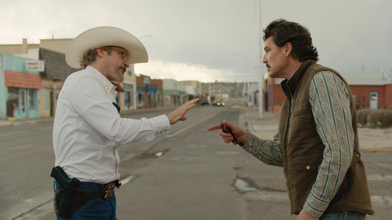 Joe Cross and Ted Garcia point at each other in the street in "Eddington" (2025)