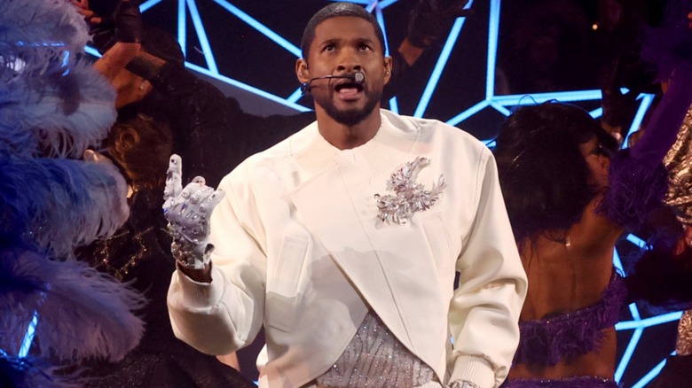 Usher singing onstage white outfit