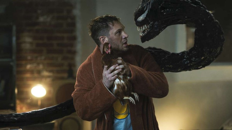 Eddie Brock holding a chicken