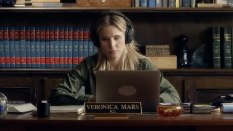 Veronica wearing headphones and looking at her computer while sitting at a desk