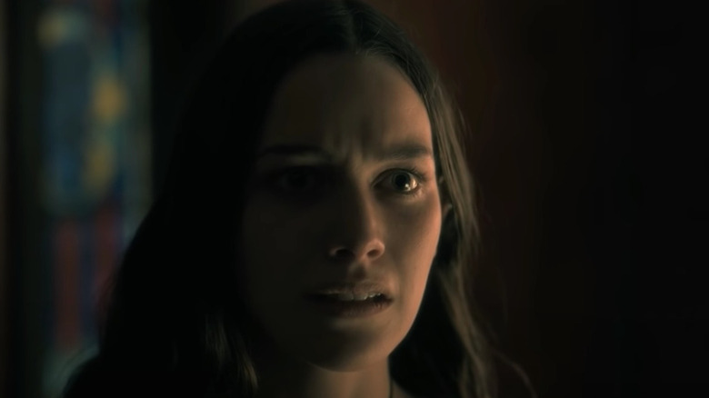 Pedretti stands in half darkness