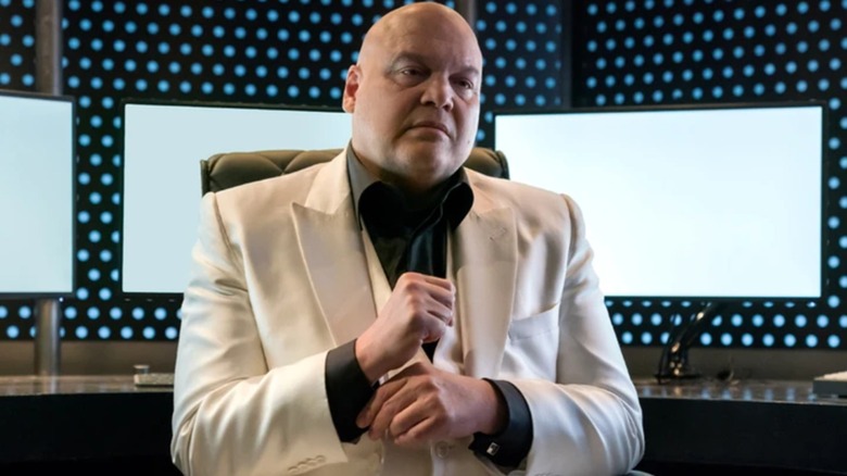 Kingpin seated wearing white suit