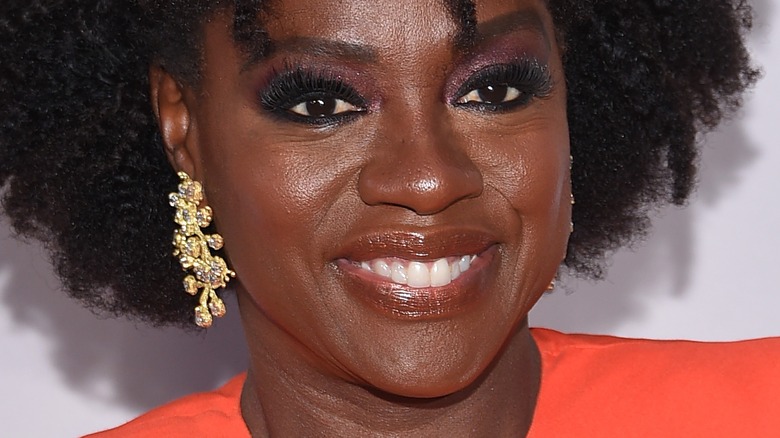 Viola Davis in a red dress with gold earrings