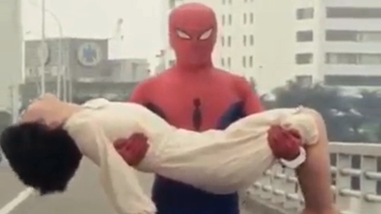 Spider-Man carrying a woman