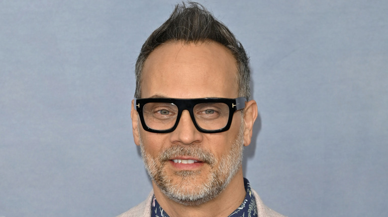 Todd Stashwick smiling in front of blue background