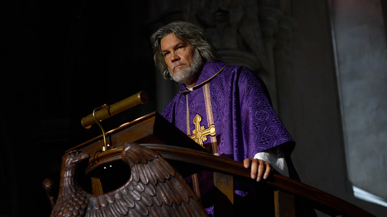 Wicks stands at a pulpit in "Wake Up Dead Man: A Knives Out Mystery" (2025)