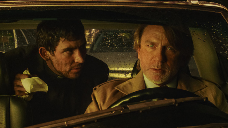 Rev. Jud Duplenticy and Benoit Blanc sitting in a car in 