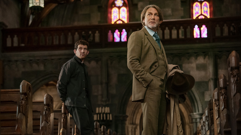 Jud and Benoit Blanc standing in church aisle in "Wake Up Dead Man: A Knives Out Mystery" (2025)