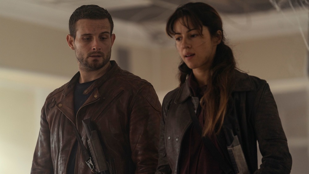 Annet Mahendru as Huck and Nico Tortorella as Felix debate Silas on The Walking Dead: World Beyond