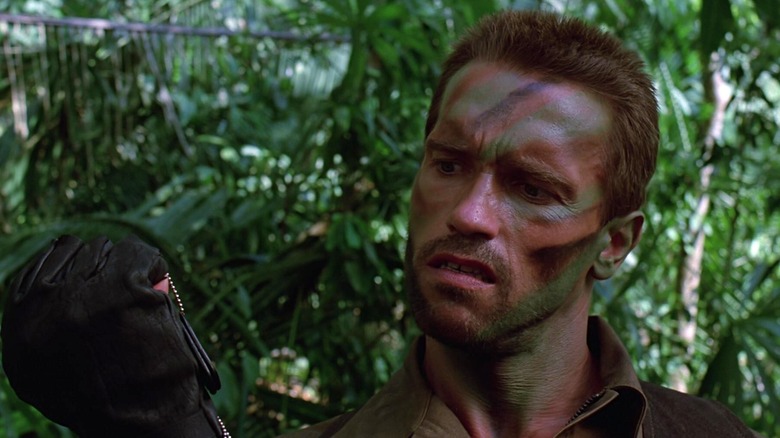 Arnold Schwarzenegger's Dutch Schaefer looking at a tag in Predator