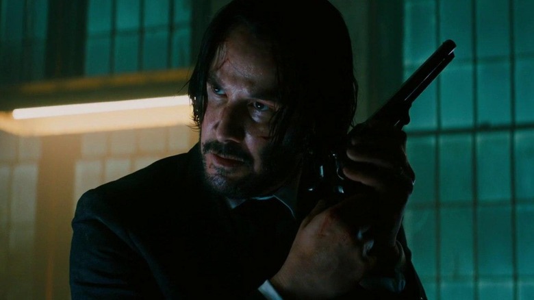 John holds a revolver chamber to his ear in "John Wick: Chapter 3 -- Parabellum" (2019)
