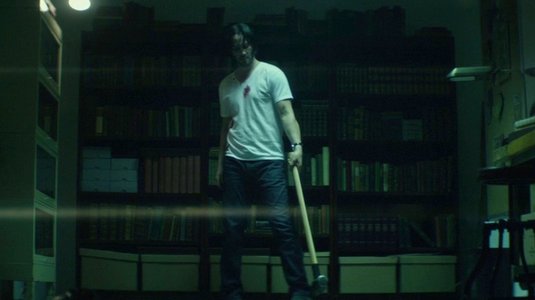 John stands with a sledgehammer in his workshop in "John Wick" (2014)
