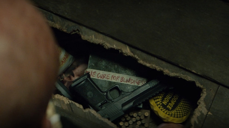 A gun and a box under floorboards