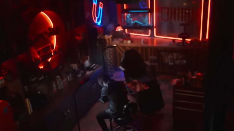 Eric tattooing himself below a neon horseshoe in Final Destination: Bloodlines