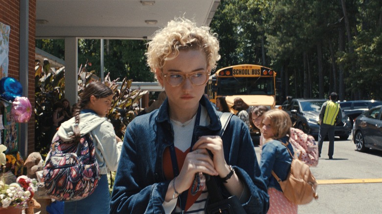 Justine nervously holding bag strap outside of school in Weapons