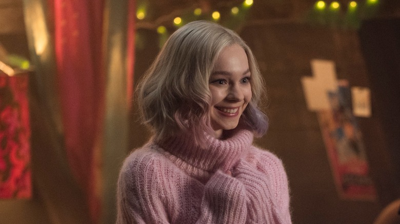 Enid smiling in a pink sweater