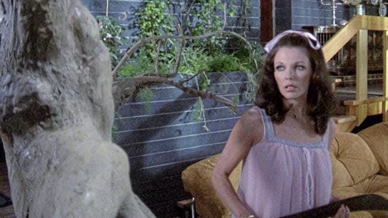 Joan Collins glares at a tree
