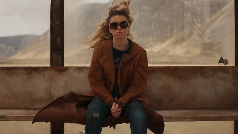 Kara sits on a windy bus stop bench in "Supergirl" (2026)