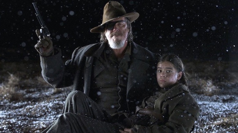 Marshal Rooster Cogburn brandishing his firearm while holding Mattie Ross in "True Grit"