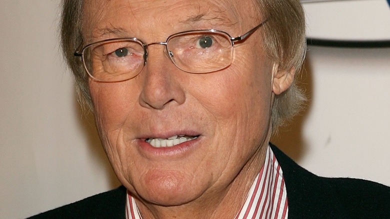 Adam West wearing glasses and a striped shirt