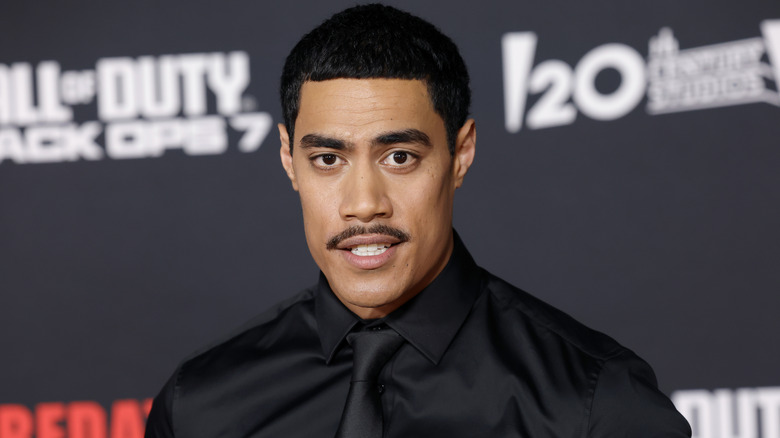 Dimitrius Schuster-Koloamatangi posing on the Predator: Badlands red carpet