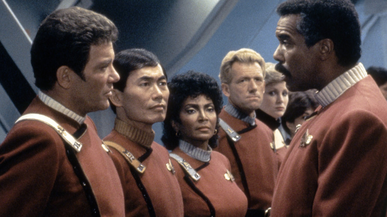 Star Trek cast posing in their red uniforms