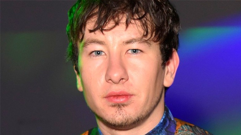 Barry Keoghan poses under green and blue lights