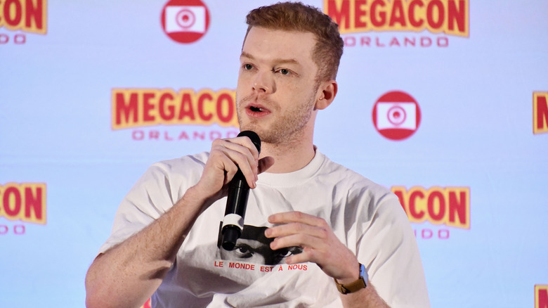 Cameron Monaghan speaking on a microphone at Megacon