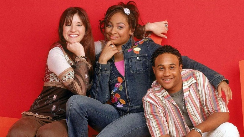 Anneliese van der Pol, Raven-Symoné, and Orlando Bloom posing on chairs.
