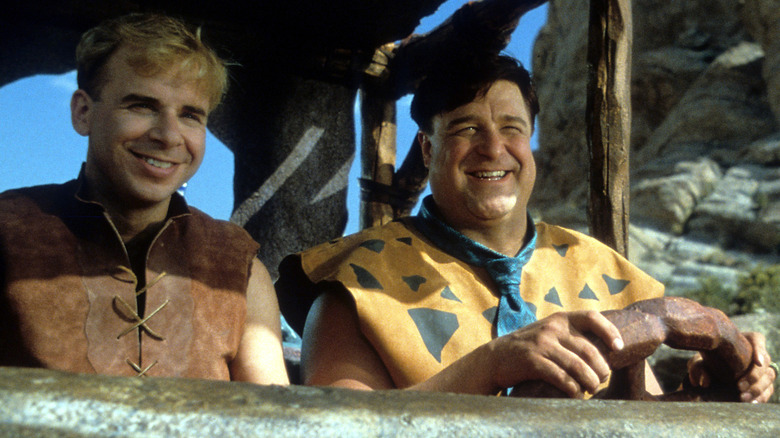 Barney and Fred smiling in a car in The Flintstones (1994)