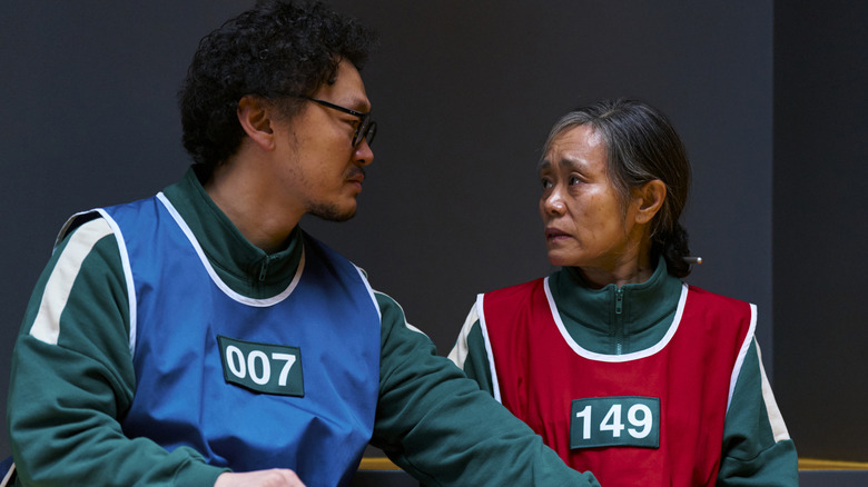 Yong-sik comforting Geum-ja before hide and seek in Squid Game