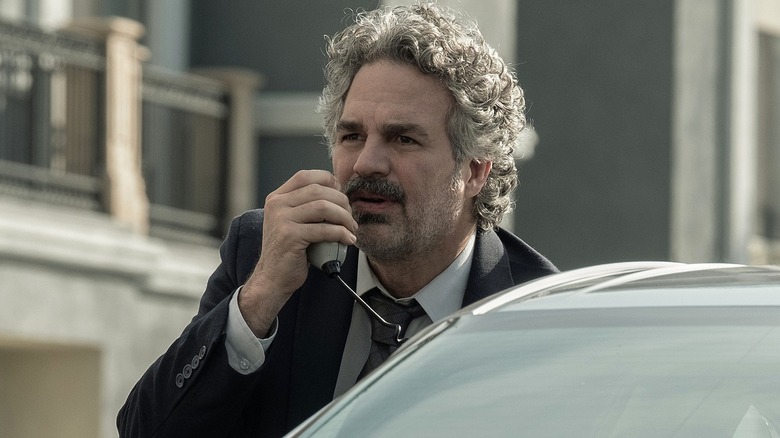 Lou hiding behind a car in Crime 101 (2026)