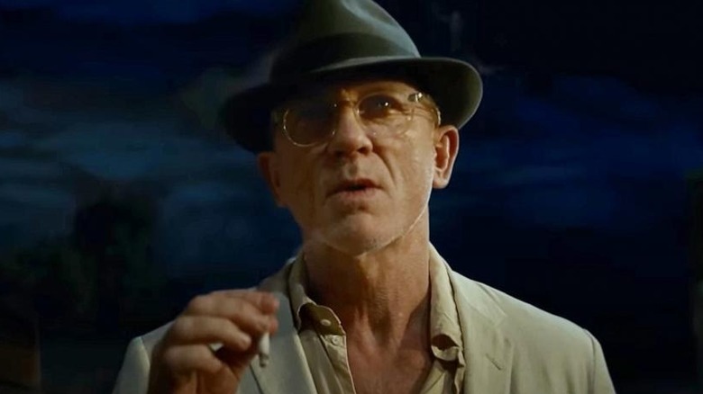 William Lee holds a cigarette at night in "Queer" (2024)